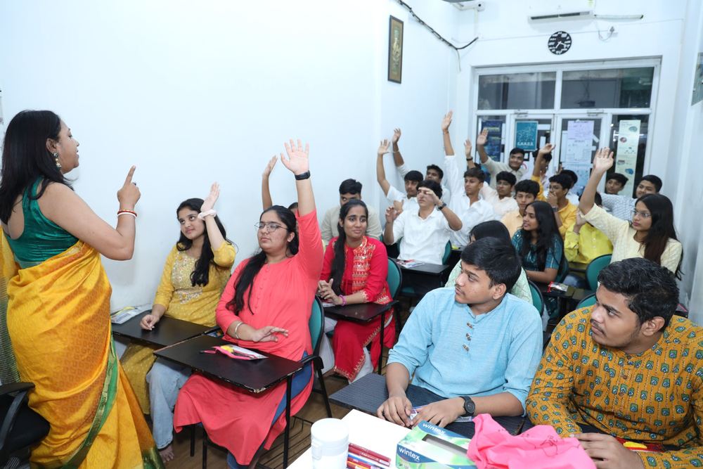 Students raising their hands to answer a question in a TBTLC classroom