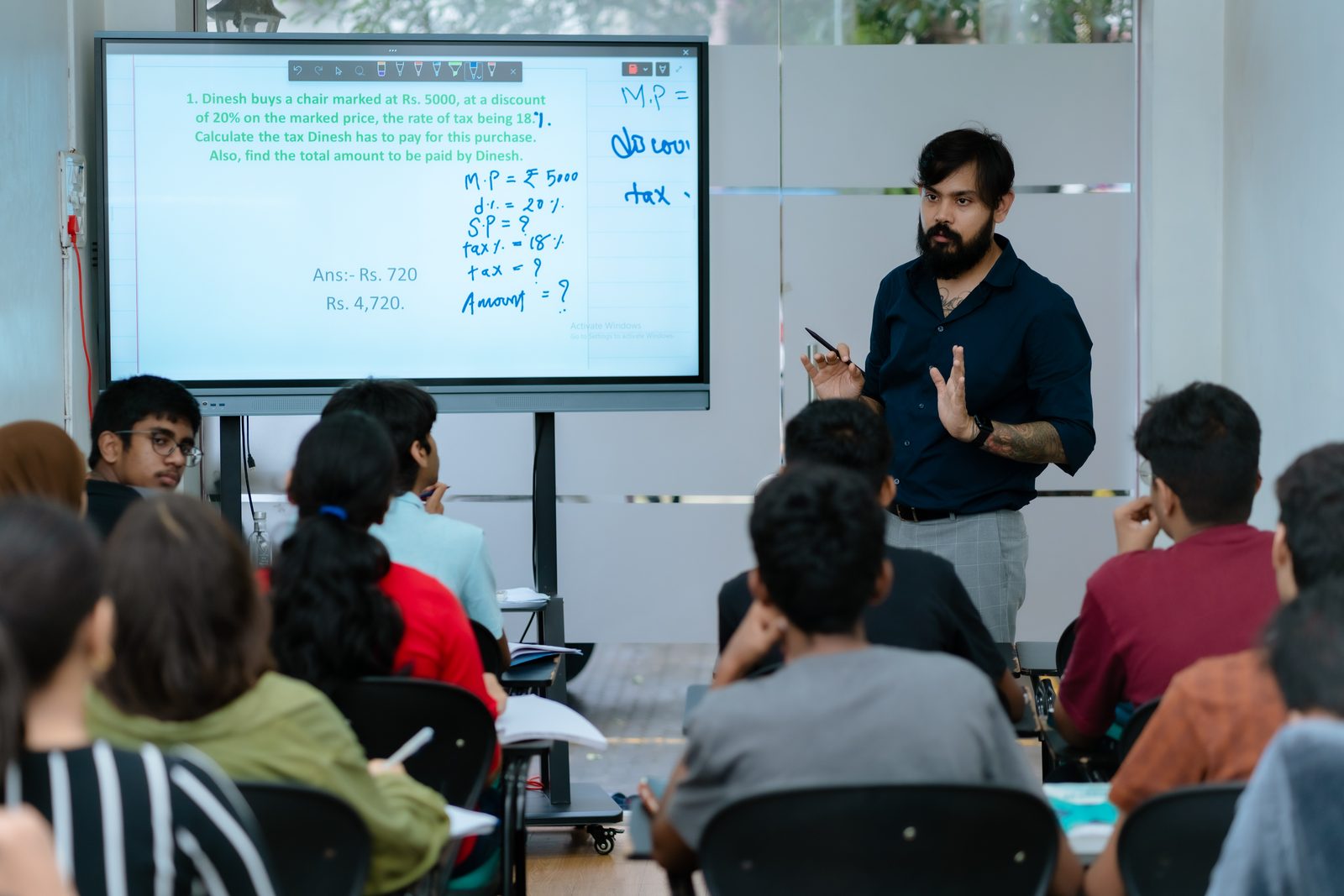 Jay Kothari teaching a Mathematics class on the smart board at TBTLC