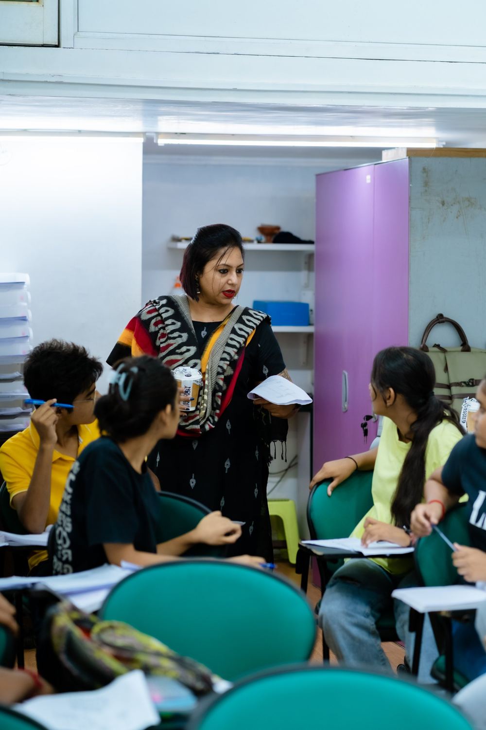 Urmi Kothari discussing a worksheet with students